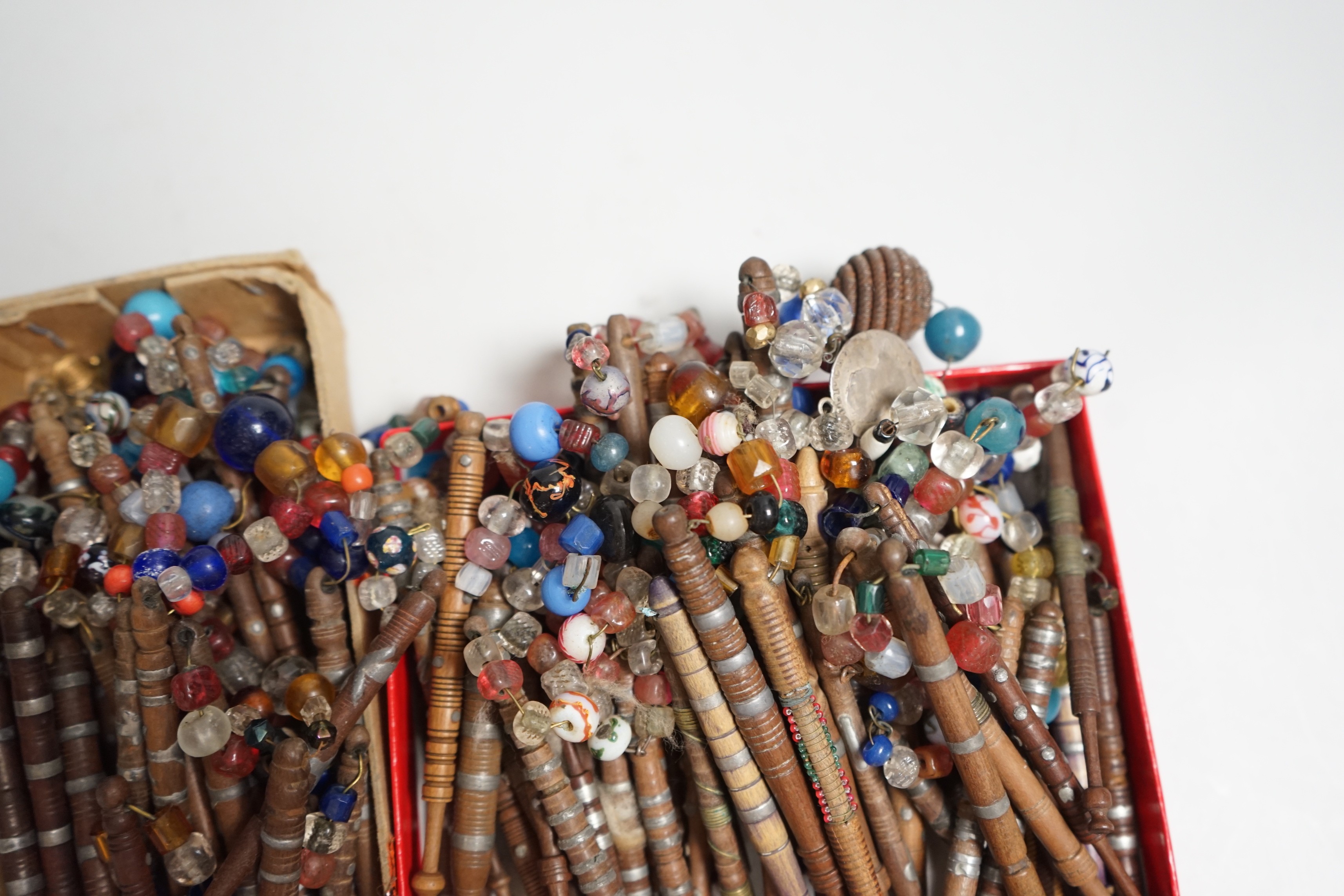 Eighty 19th century wood and metal decorated lace bobbins with coloured beaded tops